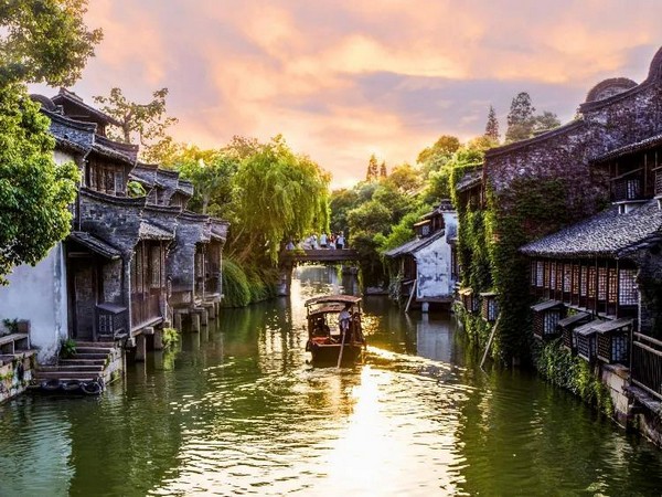 Vẻ đẹp Ô Trấn Trung Quốc yên bình với những mái ngói rêu phong in bóng xuống dòng kênh xanh phẳng lặng. Những cây cầu đá cổ kính nối liền hai bờ bến nước tạo nên một bức tranh thủy mặc đậm chất Giang Nam.